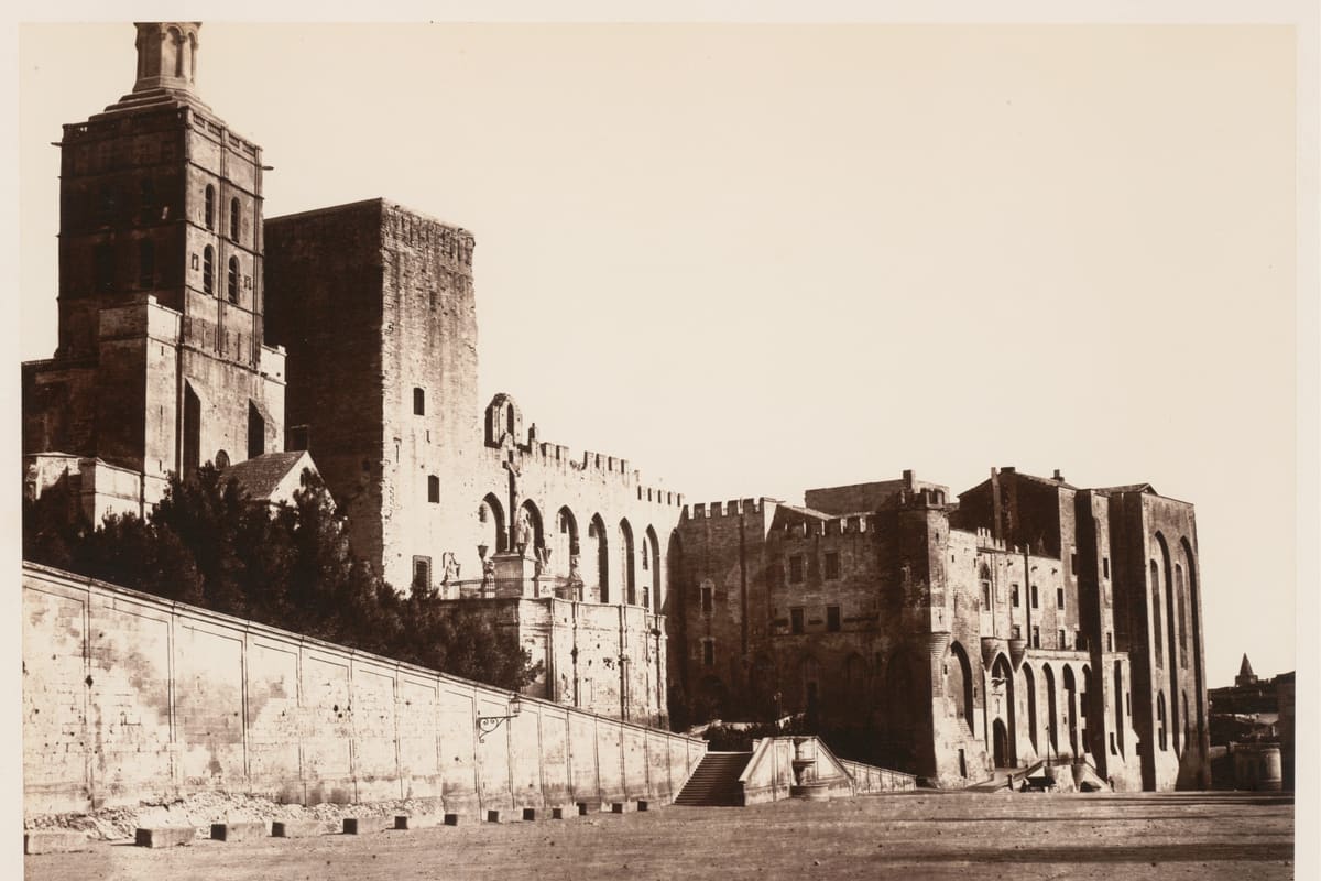 The Palais des Papes in Avignon, France — a 14th-century Gothic papal palace with massive twin-tower facade, UNESCO World Heritage since 1995, seat of the Avignon Papacy 1309–1377.